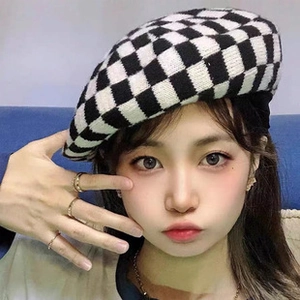 Close-up detail of knitted black and white checkerboard beret on female model