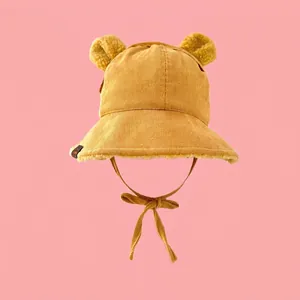Detail of yellow corduroy baby winter hat with plush bear ears and chin straps