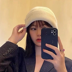 Detailed knit texture of white slouchy beanie with stylish rolled edge on model