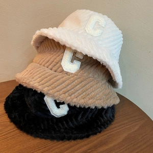 Detailed close-up of velvet beanies in white, khaki, and black with embroidered letter C