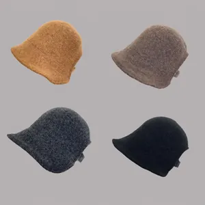 Detail view of knitted slouchy beanies in caramel, taupe, dark grey and black colors