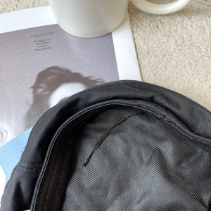 Detailed close-up of the black beret interior seams and adjustable inner drawstrings