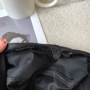 Detail of the adjustable hook-and-loop strap and twill fabric inside the black beret
