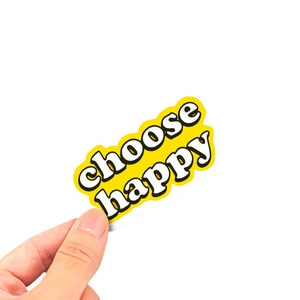 Main tenant un autocollant jaune 'choose happy' de 4cm pour téléphone et frigo