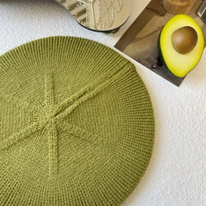 Top view of avocado green knit beret showing detailed star-shaped weave texture