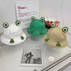 Chapeaux bob grenouille mignons en vert, blanc et kaki présentés sur une étagère
