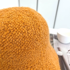 Dettaglio macro del tessuto pile arancione che mostra la trama granulosa e la finitura felpata