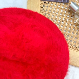 Close-up of red faux rabbit fur beret featuring soft plush texture and fluffy design