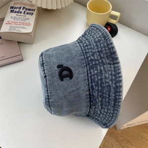 Dettaglio cappello pescatore in denim blu con ricamo 3D e texture lavata