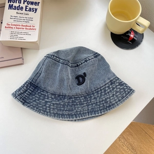 Dettaglio del cappello pescatore in denim con lettera D ricamata e cuciture rinforzate