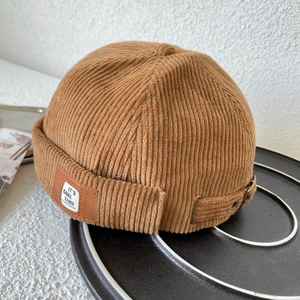 Close-up of brown corduroy dockers hat with leather patch and adjustable metal buckle