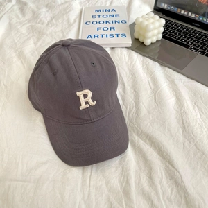 Detailed view of dark grey baseball cap with white letter R embroidery on cotton twill