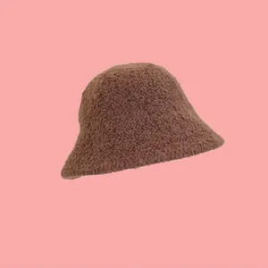 Dettaglio del cappello a secchiello in lana di agnello marrone con morbida texture felpata