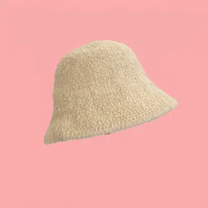 Dettaglio del cappello alla pescatora in maglia beige con motivo a trama ondulata