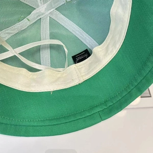 Détail de l'intérieur du bob vert avec doublure en maille respirante et cordon de serrage réglable
