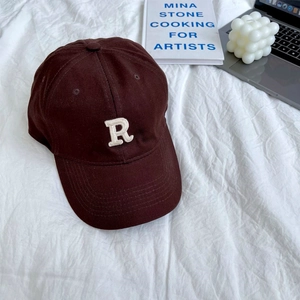 Detail of white R letter towel embroidery on dark brown cotton baseball cap