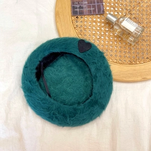 Detail view of the soft faux rabbit fur lining and adjustable strap inside the teal beret