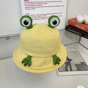 Détail d'un chapeau bob grenouille jaune avec yeux verts et broderie en coton