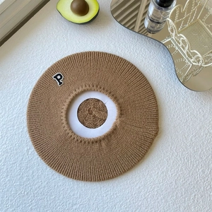 Close-up of caramel brown knitted beret featuring a vintage letter P embroidery patch