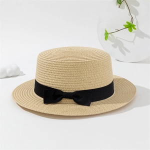 Gros plan d'un chapeau de paille canotier avec ruban gros-grain noir et noeud