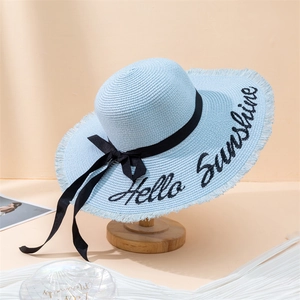 Detail of light blue straw sun hat featuring Hello Sunshine embroidery and a black ribbon