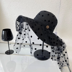 Chapeau de paille noir à large bord avec voile en résille à pois et logo doré