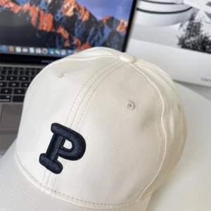 Detail of cream oversized baseball cap with black embroidered P letter on high-quality cotton