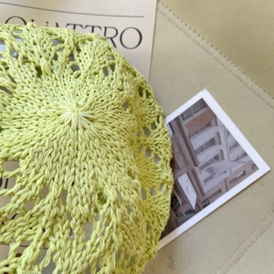 Vue détaillée du motif au crochet sur le béret en maille vert clair avec décoration