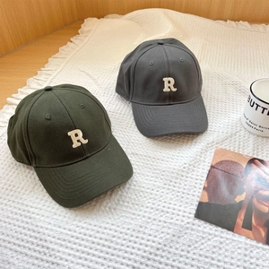 Detailed close-up of cotton baseball caps with 3D letter R embroidery in gray and dark green