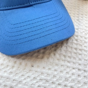Detail of light blue baseball cap brim with durable reinforced parallel stitching