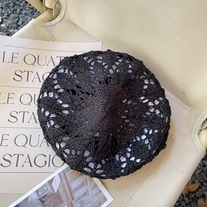 Gros plan détaillé d'un béret noir en crochet ajouré avec des motifs floraux élégants