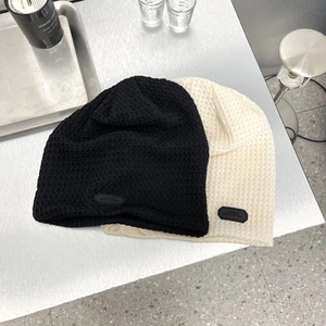 Berretti stile giapponese in maglia a nido d'ape neri e beige su piano in metallo