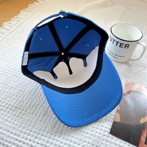 Detail of blue cotton baseball cap interior with quality stitching and metal buckle