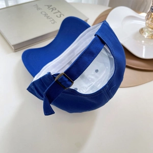Detail of Klein blue cotton baseball cap showing adjustable bronze metal buckle and strap