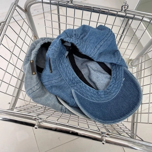 Blue denim newsboy cap in dark and light wash with metal rivet leather tag detail