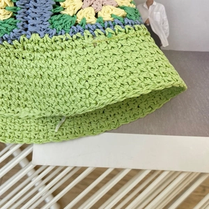 Detail van handgehaakte zonnehoed met kleurrijke bloemmotieven en geweven textuur