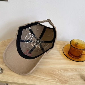 Detailed interior of khaki baseball cap with embroidery, sweatband and inner structure