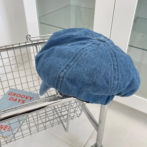Detailed macro of a vintage blue denim beret hat with octagonal stitching and top button