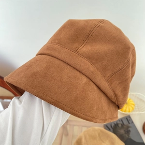 Detail van karamel suède vissershoed met getextureerde stiksels en zachte stof