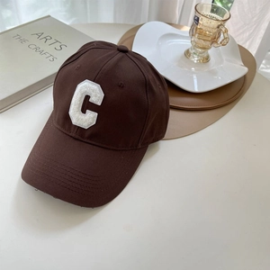 Detail view of the vintage brown cotton baseball cap featuring a white towel embroidered C logo