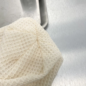 Dettaglio macro della trama in maglia a nido d'ape color crema e tessuto traspirante