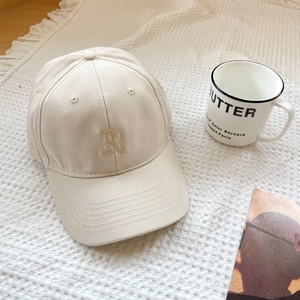 Close-up of beige baseball cap featuring a premium R letter embroidery on cotton twill