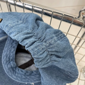Detailed macro view showing blue denim fabric texture and folds of the octagonal beret hat