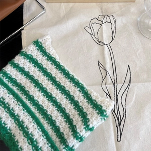 Detail of green and white striped knit texture on a beanie with thick weave pattern