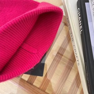 Dettaglio del berretto in maglia a coste rosa acceso con trama spessa e calda lana