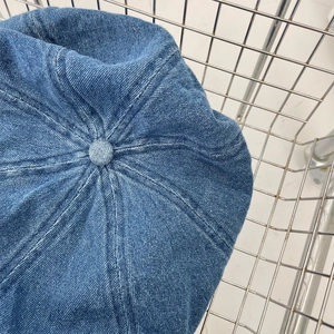Close-up of vintage dark blue denim octagonal hat with twill texture and fabric button