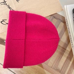 Dettaglio della trama del berretto in maglia a coste rosa rosso in un set flat lay accogliente
