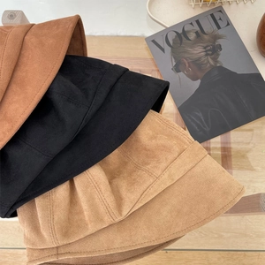 Detailopname van suède vissershoeden in kaki, zwart en bruin met fijne stiksels erop