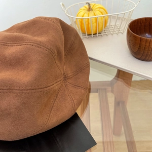 Gedetailleerde close-up van bruin suède en stiksels op een vintage baret voor herfst