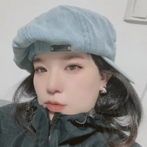 Light blue denim octagonal baker boy hat with vintage leather patch on a model